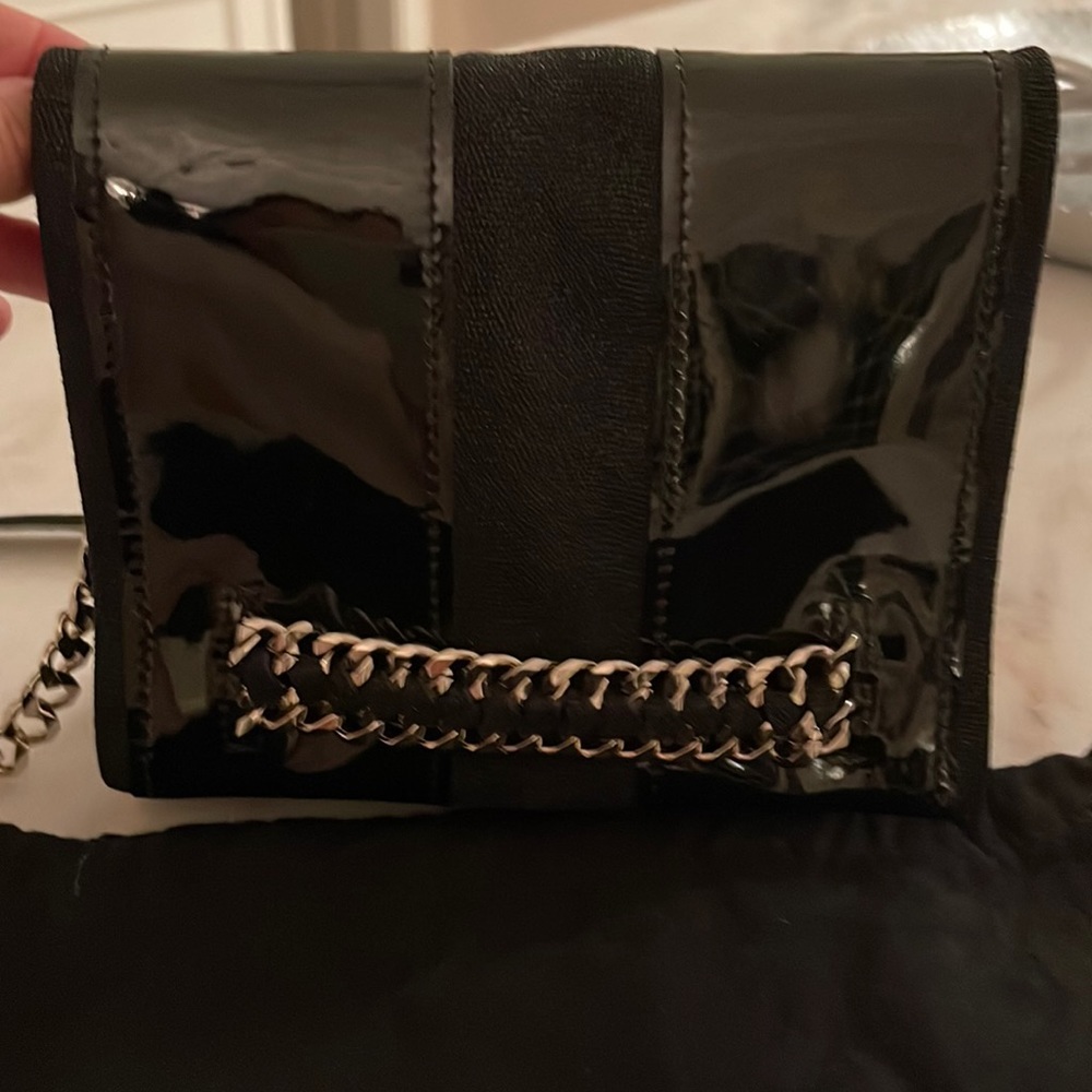 Ramy Brook black patent cross body bag with magnetic closure ;zipper under flap